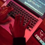 person using laptop with code on screen